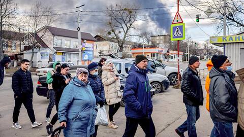 La gente hace fila frente a una tienda de comestibles en Vasilkiev. La nube de humo proviene de un depósito de petróleo que los rusos destruyeron el día anterior.