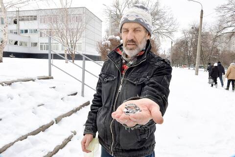 Un hombre en Kharkiv muestra fragmentos de cámara de una bomba de racimo diseñada para herir a tantas personas como sea posible.