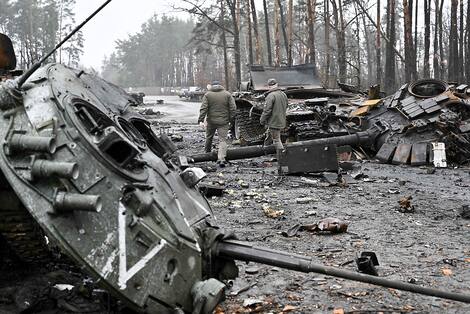 Topshot - Ucrania - Rusia - Conflicto Soldados ucranianos caminan entre tanques rusos destrozados en el pueblo de Dmitrievka, en las afueras occidentales de Kiev.