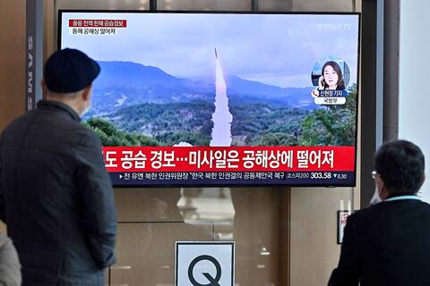 Seul'deki bir tren istasyonundaki insanlar, Kuzey Kore'nin füze denemesinin belgesel görüntülerini izliyor.
