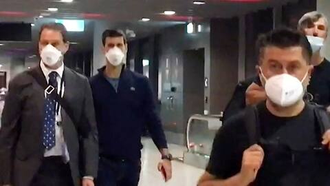 An image from an Australian TV station showing Novak Djokovic (background) at Melbourne Airport preparing to leave Australia today.