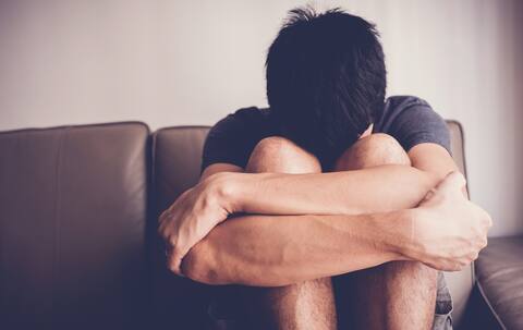 Depressed and anxiety young man sitting alone at home, mental health concept