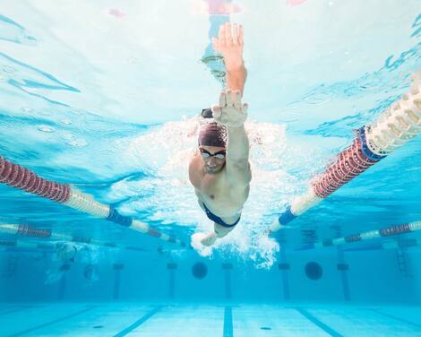Professional man swimmer inside swimming pool.  Underwater panoramic image. Professional man swimmer inside swimming pool.  Underwater panoramic image.