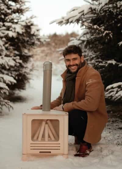 Mathieu Cloutier and his sons in front of a decorative wood stove.