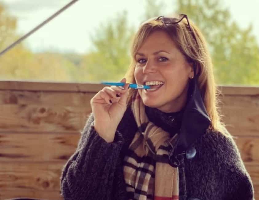 Patricia Paquin s'assoit sur une grosse citrouille