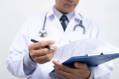 Male doctor writing prescription