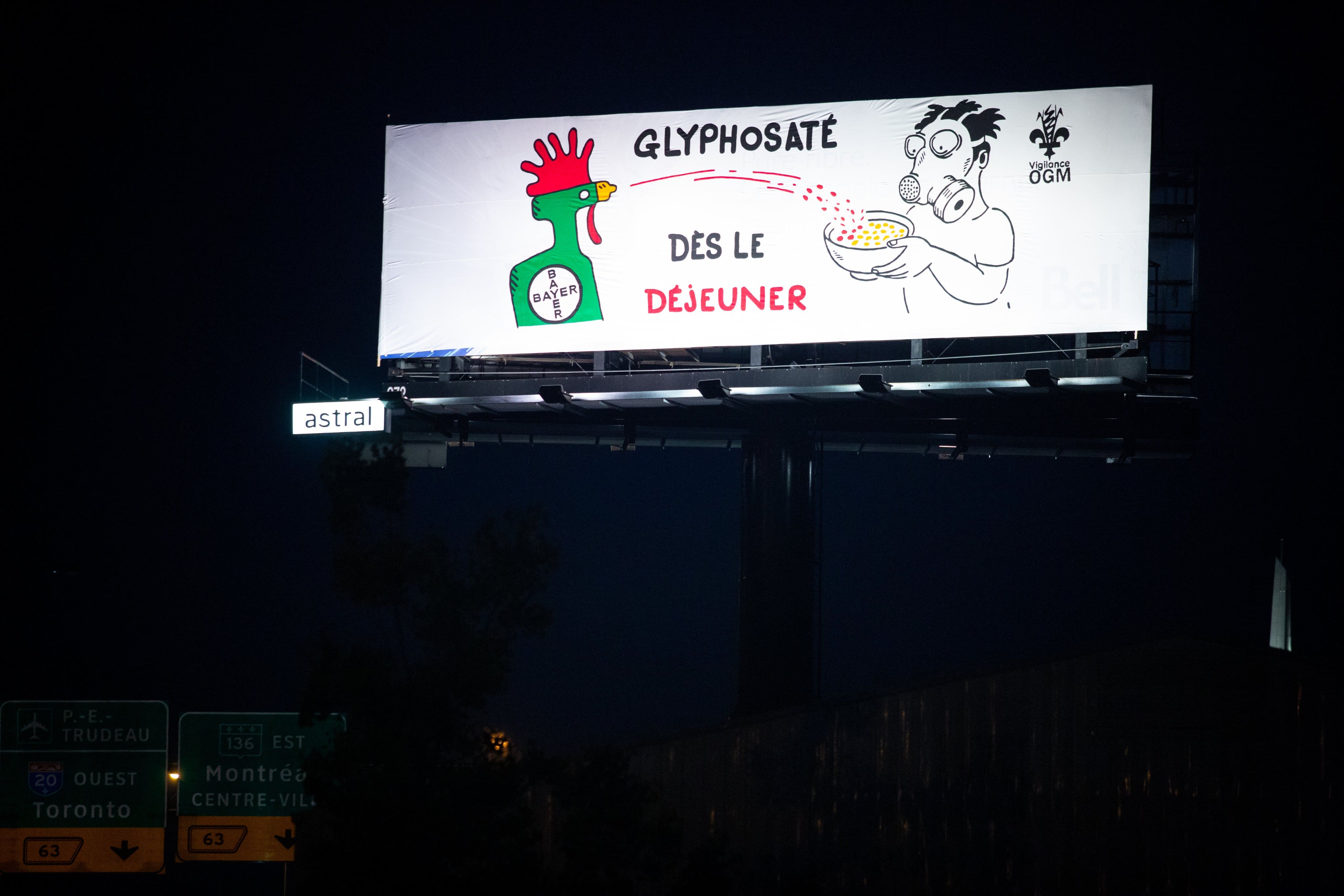 Vigilance OGM escalade un panneau publicitaire et y installe sa banni&egrave;re