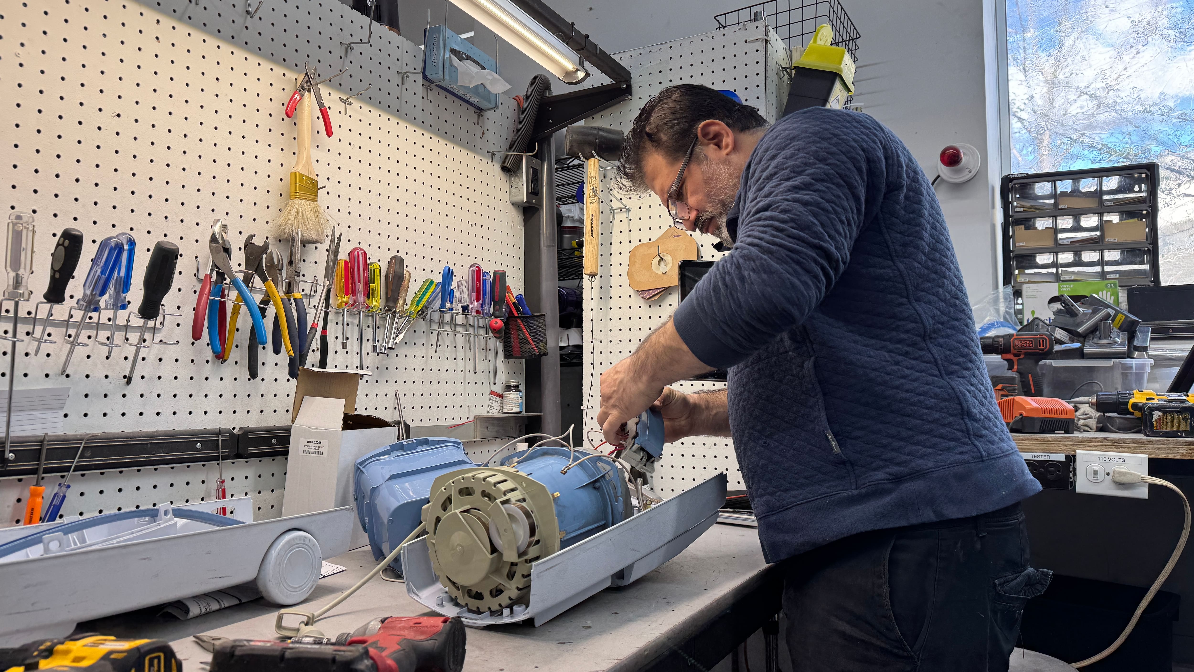 Un technicien répare un aspirateur.