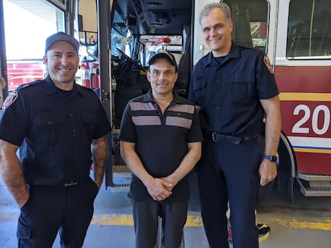 At the center, Dominic Hemelin is surrounded by two firefighters who saved him from a burning house: Jean-Sebastien Bowlinger (left) and Matthew Brown (right), who played in the NHL before becoming a firefighter in 2015.