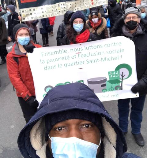 Yasmine Belam, chargée de concertation en habitation pour la table de quartier Vivre Saint-Michel en santé, en arrière au centre lors d'une mobilisation.