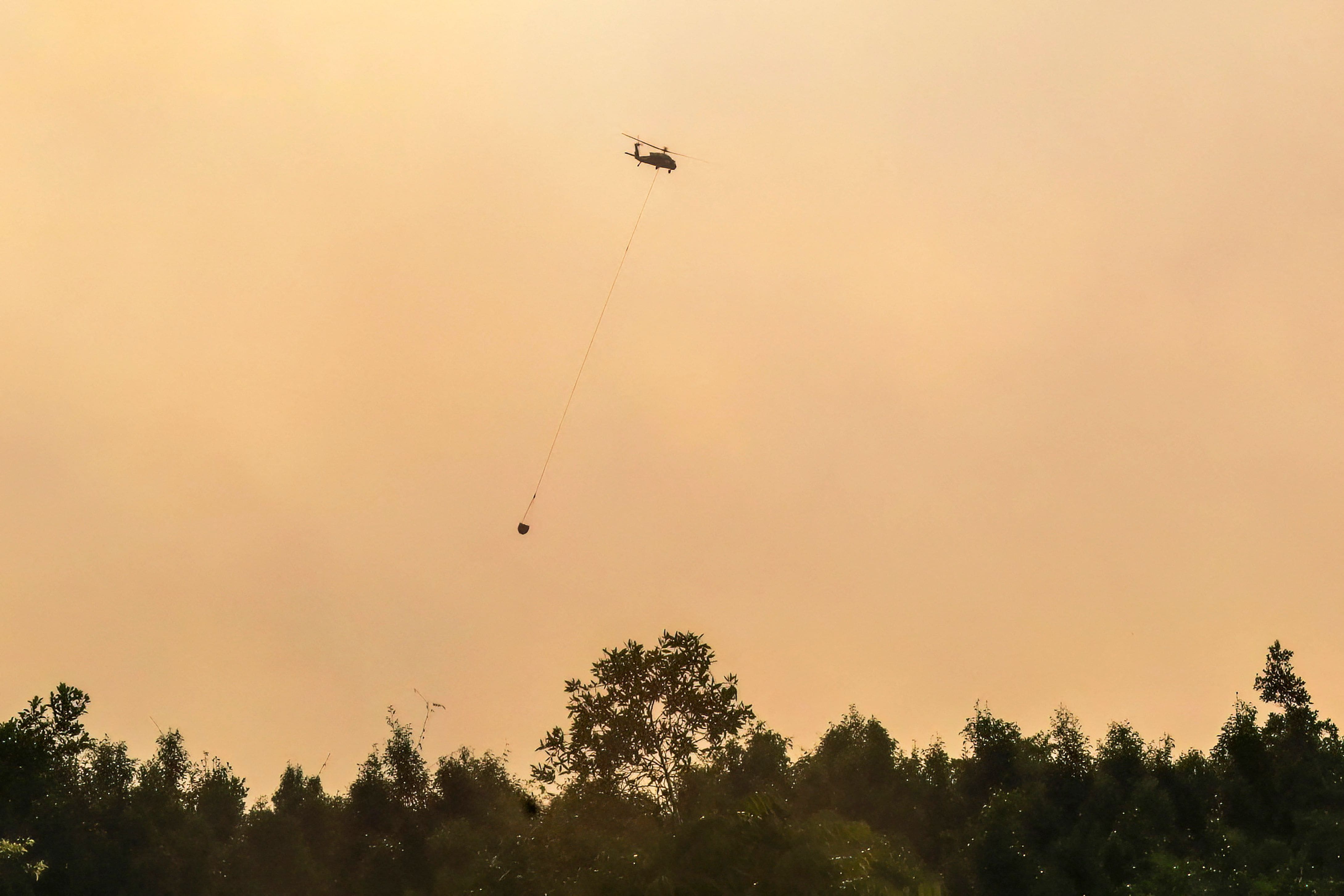 Cette photo prise le 31 juillet 2026 montre des pompiers utilisant un hélicoptère pour éteindre des feux de forêt en Indonésie, en raison d’une saison sèche prolongée. Les experts estiment qu’il s’agit d’une des pires saisons d’incendies des dernières années en raison d’un fort épisode El Niño.