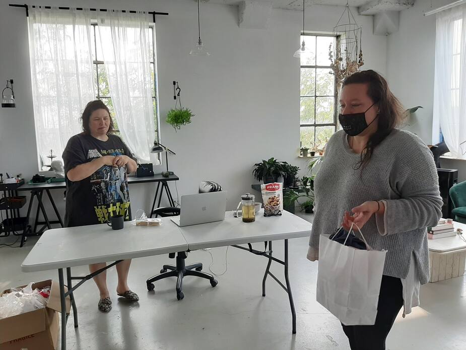 La propriétaire de l’entreprise Selv Rituel, Sarah Laroche, et l’assistante personnelle de Genie, Marie-Ève Morin, s’échangent un sac rempli de masques à transporter jusque chez le manufacturier de Selv Rituel.