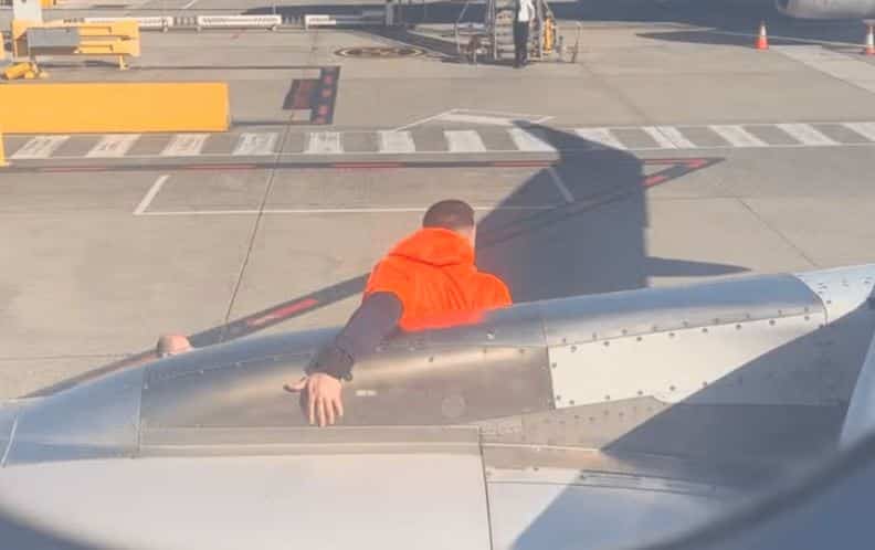 Un homme ouvre la sortie d&rsquo;urgence et marche sur l&rsquo;aile d&rsquo;un avion