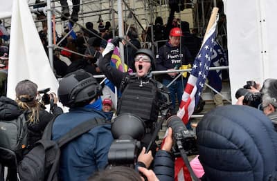 In this file photo taken on January 6, 2021, a man calls on the crowd to invade the building as Trump supporters clash with police and security forces during their attempt to storm the US Capitol in Washington DC