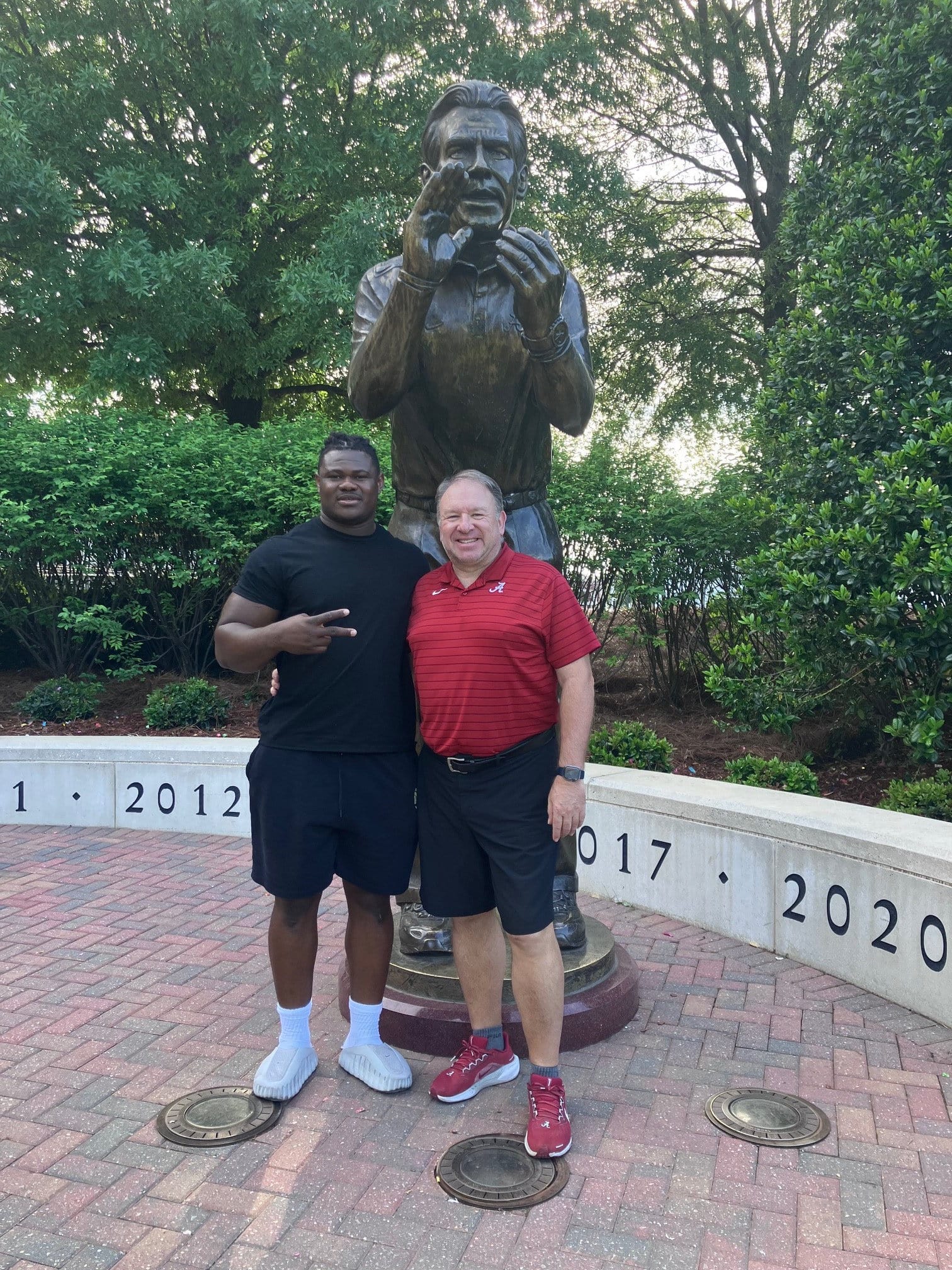 Nick Saban teve um pouco de prendre sa retraite, mas um déjà sua estátua na Universidade do Alabama, devant laquelle Steve Bolo Mboumoua e seu recruta em Lac-Mégantic Yannick Thibault em sua pose.
