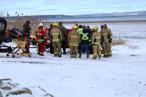 Firefighters from Sainte-Croix and officers from Sûreté du Québec recover the body of a hunter who drowned in a river.