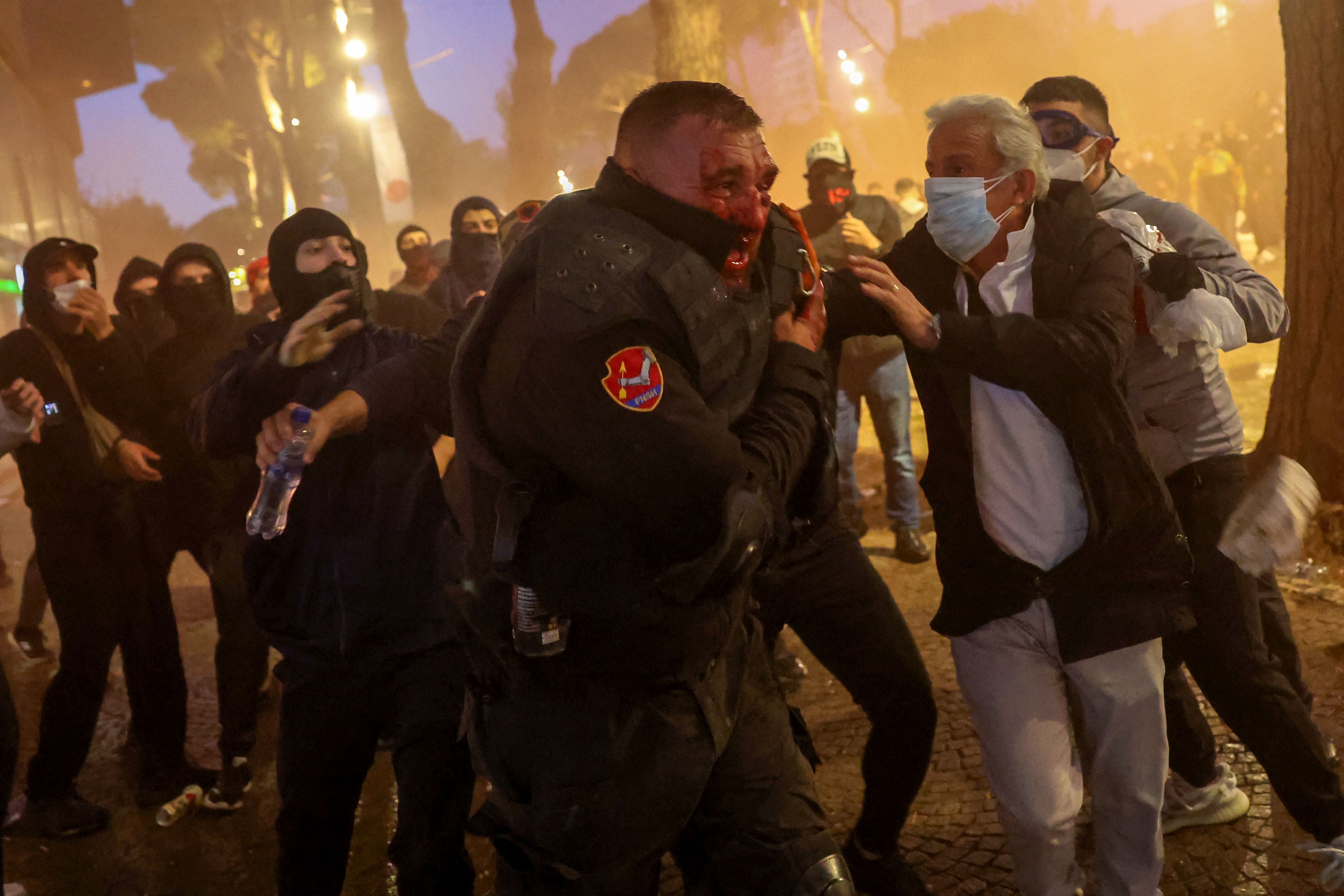 Un policier blessé fuit des manifestants lors d'affrontements dans le centre de Tirana, en Albanie, le 14 octobre 2026.
