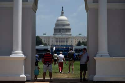 Visitors seek shade under a replica of President Trump's planned