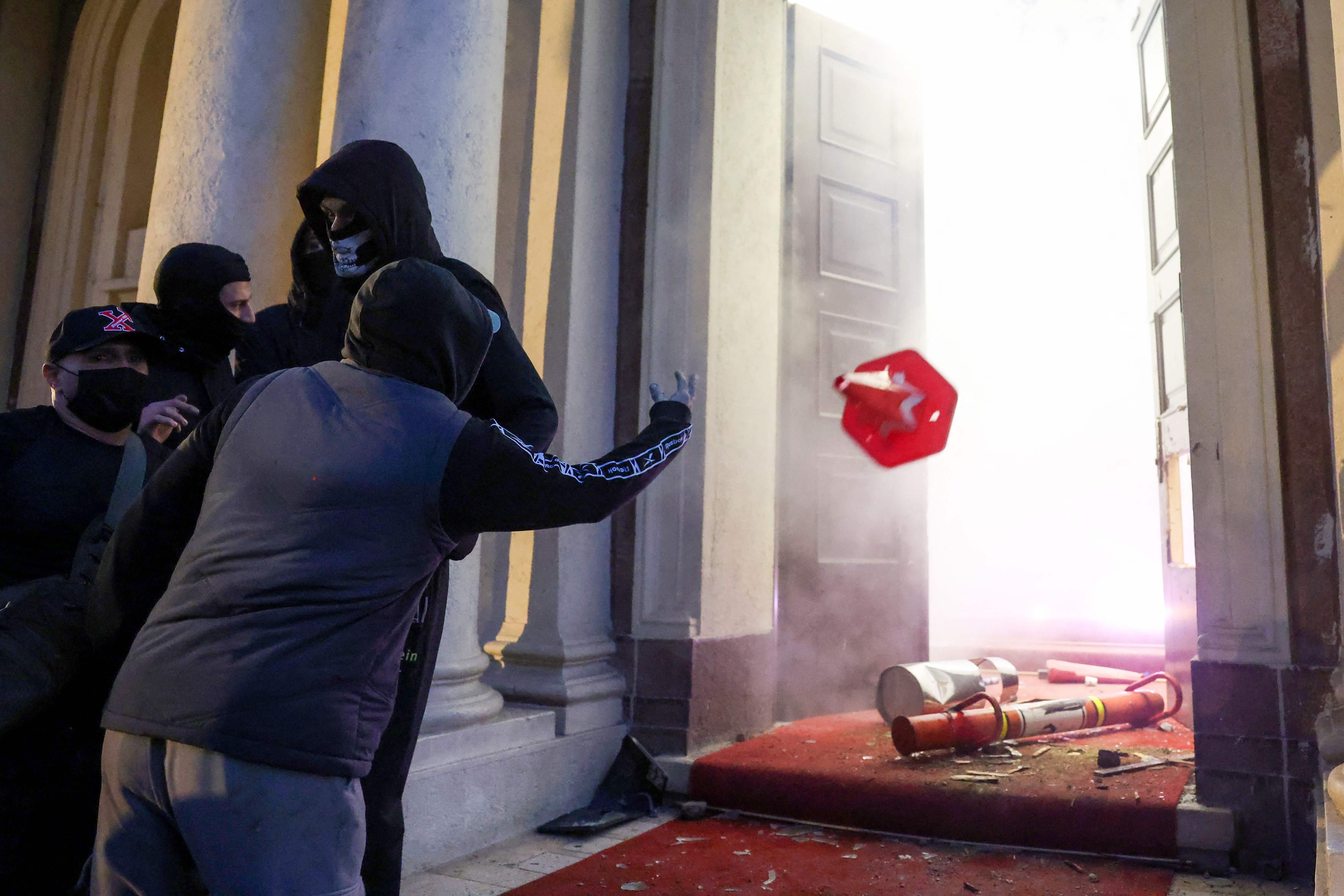 Un groupe de manifestants vandalise les bureaux du parlement albanais lors d'affrontements avec la police antiémeute dans le centre de Tirana, le 14 octobre 2026.