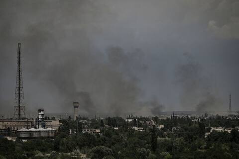 Un rescatista retira los escombros de un edificio de apartamentos parcialmente destruido por los bombardeos en las afueras de Kharkiv.