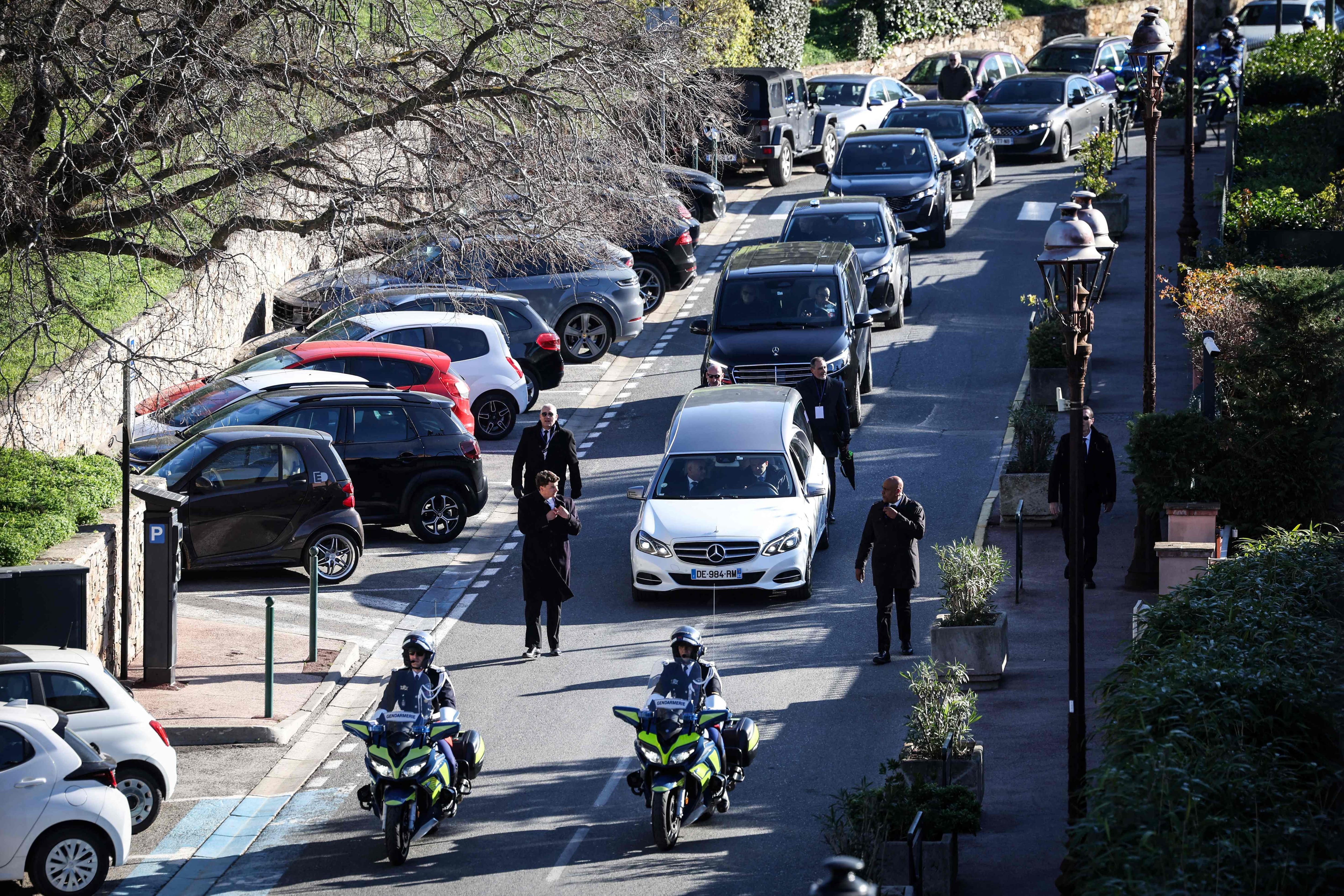A carruagem que transporta o caixão de Brigitte Bardot e o cortejo fúnebre seguem em direção ao Cemitério Naval após a cerimônia.