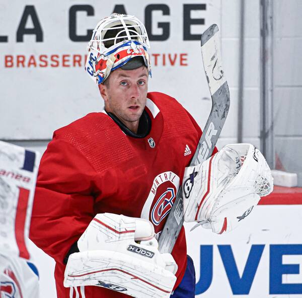 Cinq décisions prises en 2024 qui ont mal vieilli A couple stands smiling in front of their tiny home, surrounded by lush greenery.
