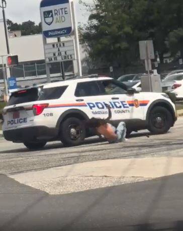 Une femme brandit une arme dans la rue et se fait happer de plein fouet par une voiture de police