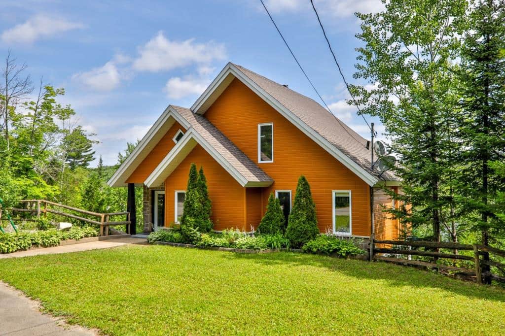 Une maison-chalet jaune à vendre pour 649 000$