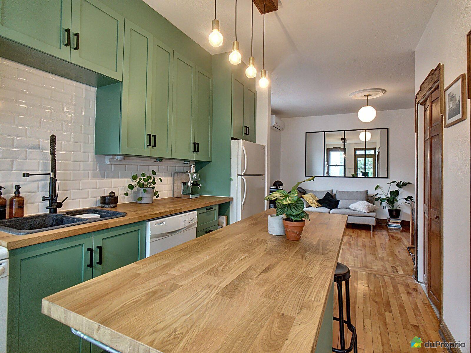 Un condo avec une cuisine verte pour 449 000$