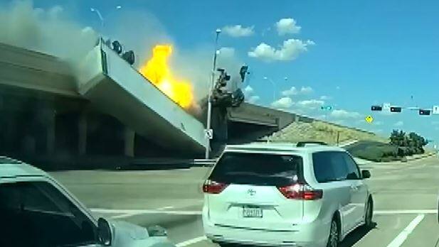A semi-trailer truck takes off from the road, tumbles from an overpass and bursts into flames on the roadway